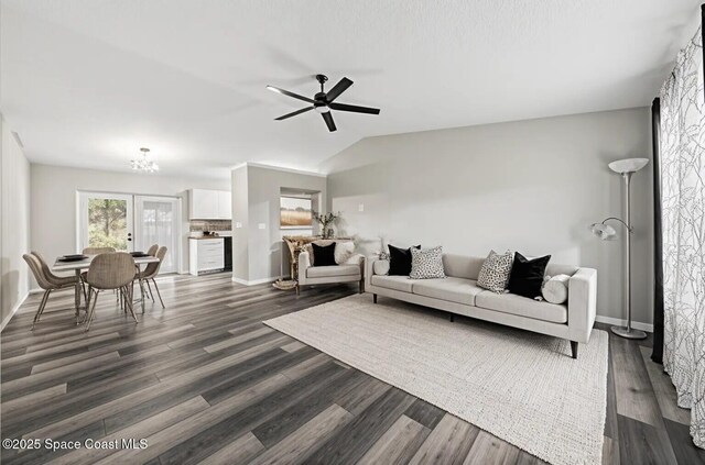 living room with ceiling fan, a chandelier, dark wood-type flooring, baseboards, and lofted ceiling