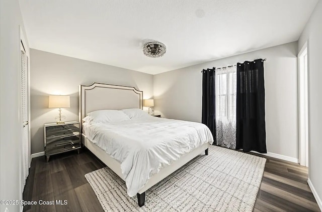 bedroom with baseboards and dark wood finished floors
