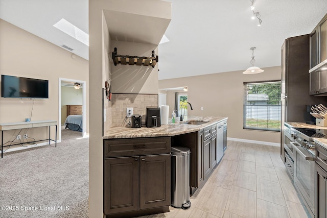 1265 Giralda Cir NW, Palm Bay, FL 32907 - kitchen with a sink, dark brown cabinets, light stone countertops, baseboards, and backsplash
