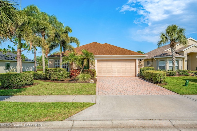 7175 Mendell Way, Melbourne, FL 32940 - view of front of property with a garage, decorative driveway, a front lawn, and stucco siding