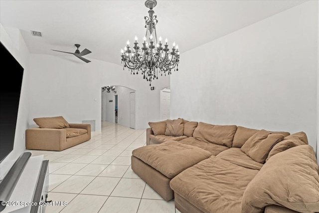living room with arched walkways, a ceiling fan, light tile patterned floors, and a chandelier