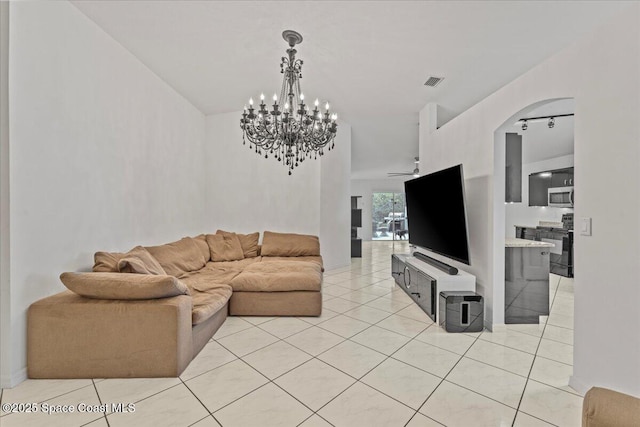 living room featuring light tile patterned floors, arched walkways, a chandelier, and ceiling fan