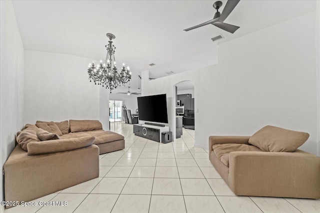 living area featuring a ceiling fan, arched walkways, a chandelier, and light tile patterned flooring