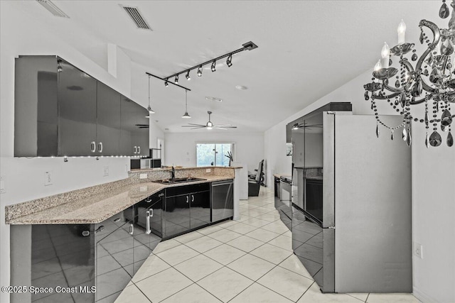 kitchen featuring freestanding refrigerator, stainless steel dishwasher, ceiling fan, a sink, and a peninsula