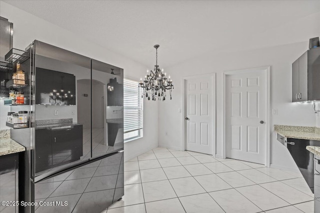 unfurnished dining area with a chandelier and light tile patterned floors