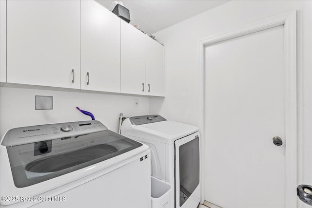 washroom featuring cabinet space and washer and dryer