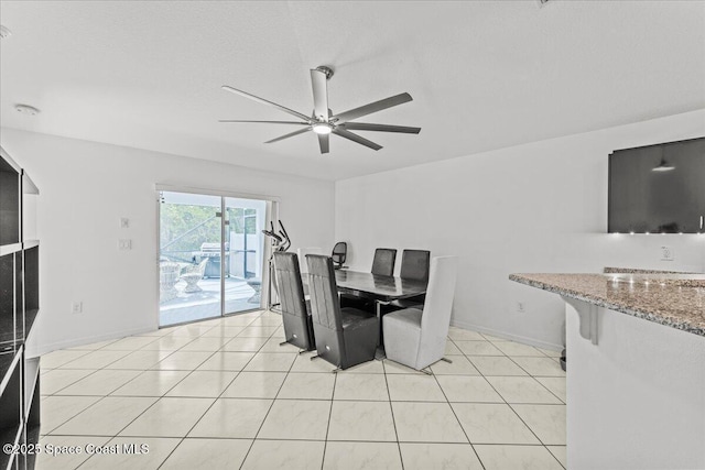 dining space featuring ceiling fan, baseboards, and light tile patterned floors