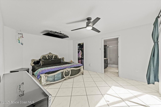 bedroom with a spacious closet, a closet, light tile patterned flooring, ceiling fan, and ensuite bath