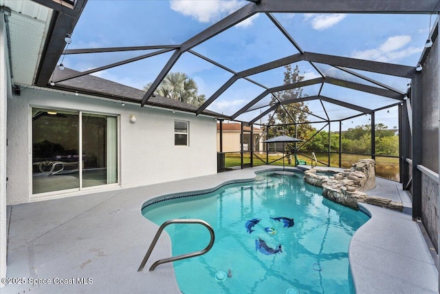 view of pool featuring a patio area, a pool with connected hot tub, and glass enclosure