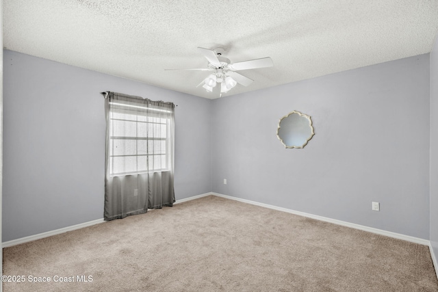 empty room with ceiling fan, carpet, a textured ceiling, and baseboards