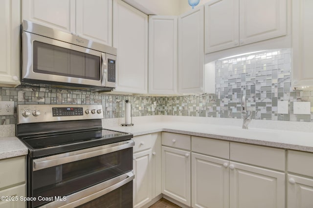 kitchen featuring backsplash, stainless steel appliances, and white cabinets