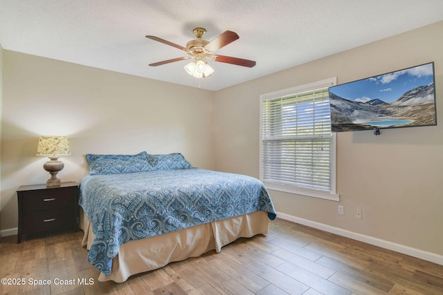 bedroom featuring ceiling fan, baseboards, and wood-type flooring