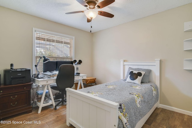 bedroom with baseboards, ceiling fan, and wood finished floors