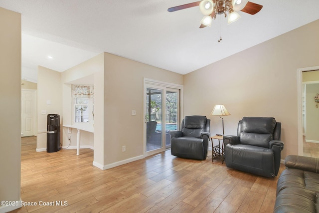 living room with ceiling fan, lofted ceiling, baseboards, and light wood-type flooring