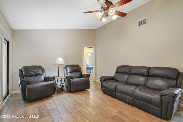 living room with vaulted ceiling, a ceiling fan, visible vents, and light wood-style floors