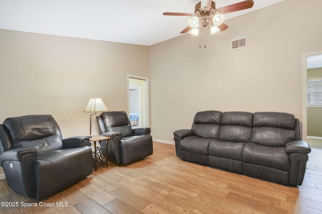 living area with light wood-type flooring, ceiling fan, baseboards, and visible vents