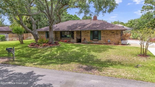 ranch-style home with a front lawn, brick siding, fence, and a chimney