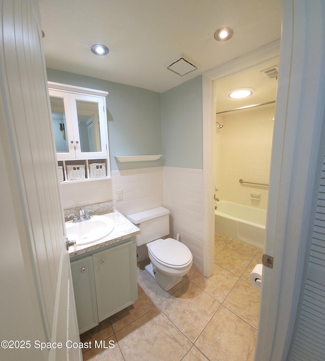 full bath with tile patterned floors, toilet, vanity, recessed lighting, and tile walls