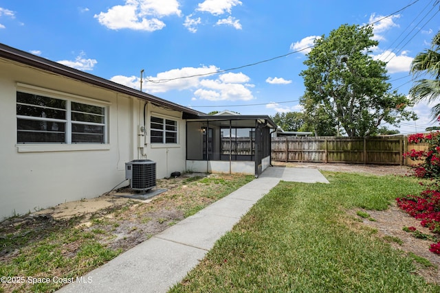 view of yard with a sunroom and central AC