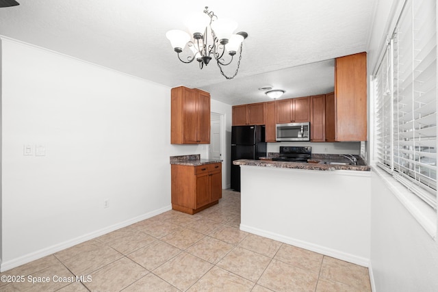 kitchen with black appliances, a chandelier, brown cabinets, light tile patterned floors, and baseboards