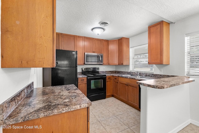 kitchen featuring black appliances, a sink, a peninsula, a textured ceiling, and dark countertops
