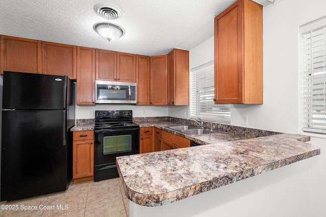 kitchen featuring black appliances, brown cabinets, and a textured ceiling