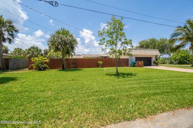 view of yard featuring concrete driveway and an attached garage