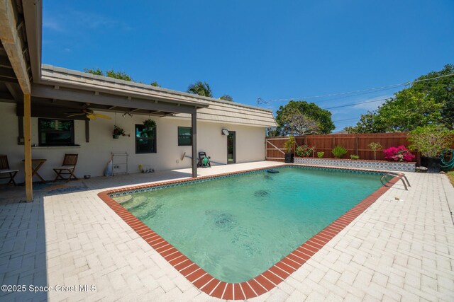 view of pool with ceiling fan, a patio area, and a fenced backyard