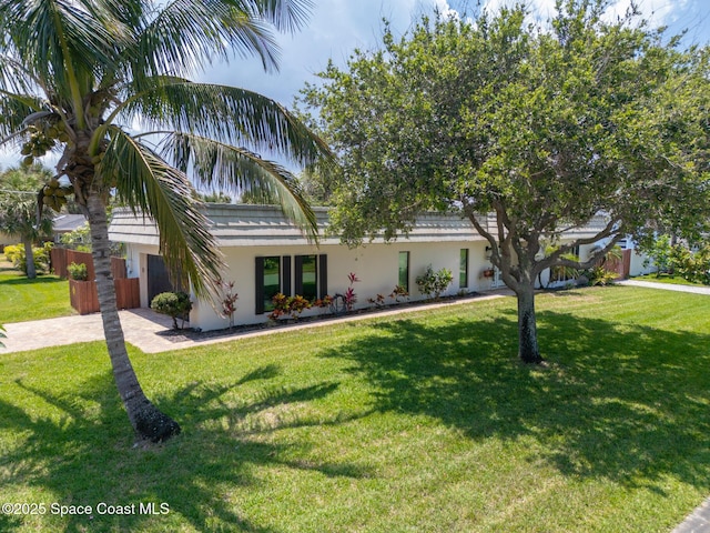 view of front of home featuring driveway, stucco siding, and a front yard