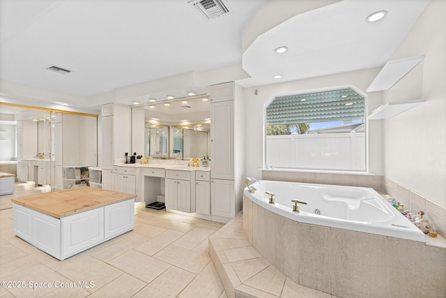 bathroom with a whirlpool tub, vanity, tile patterned flooring, and recessed lighting