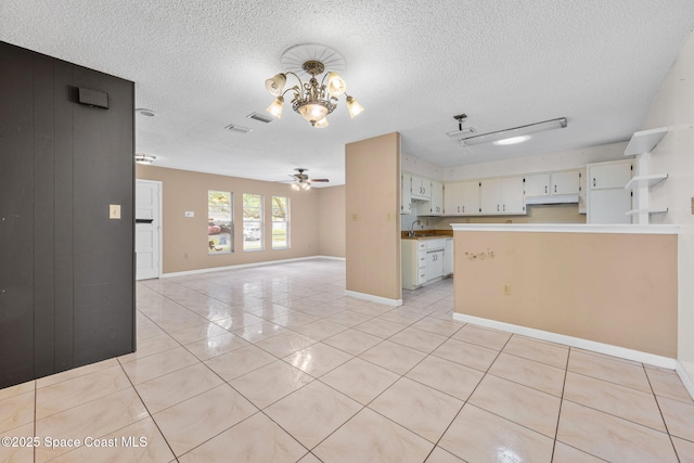 1554 Nona St NE, Palm Bay, FL 32907 - unfurnished living room featuring light tile patterned floors, a textured ceiling, a chandelier, a ceiling fan, and baseboards