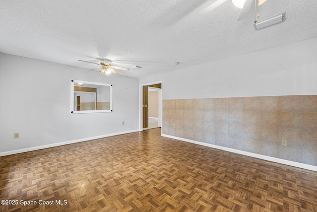 1554 Nona St NE, Palm Bay, FL 32907 - unfurnished room featuring a ceiling fan, baseboards, a textured ceiling, and a wainscoted wall