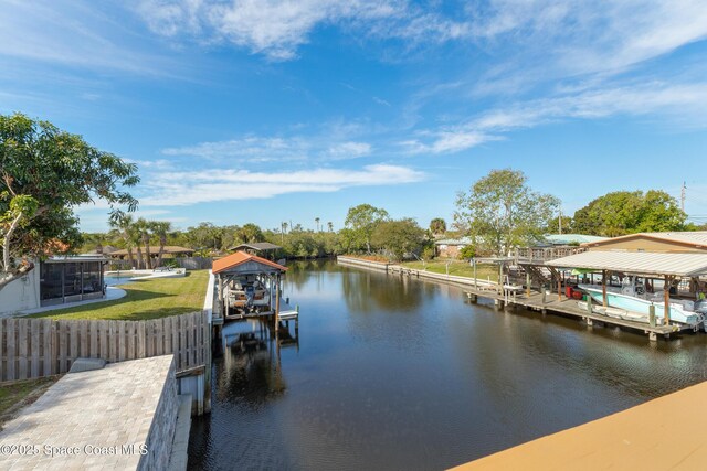 dock area featuring a water view, fence, and boat lift