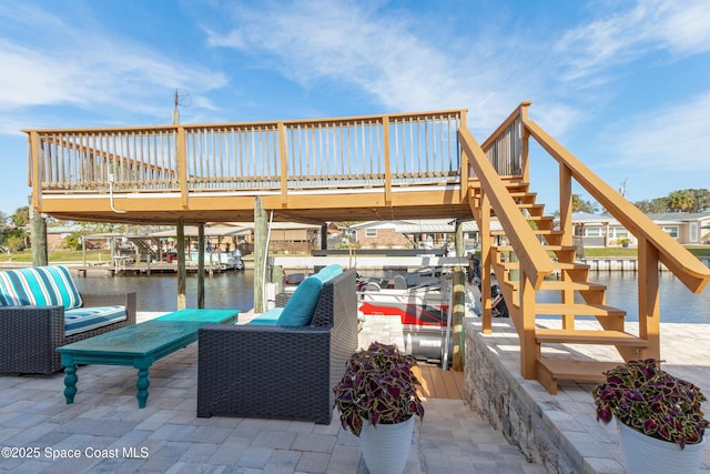 view of patio with a deck with water view, a boat dock, and stairway