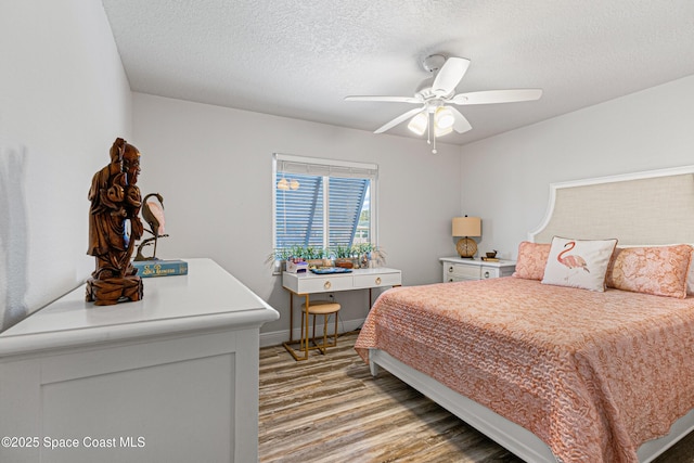 bedroom featuring baseboards, light wood-style floors, ceiling fan, and a textured ceiling