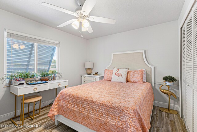 bedroom with ceiling fan, baseboards, a closet, and wood finished floors