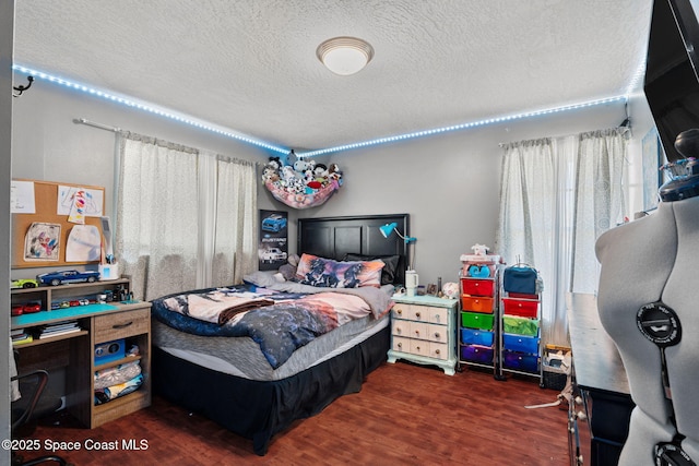 bedroom featuring a textured ceiling and wood finished floors