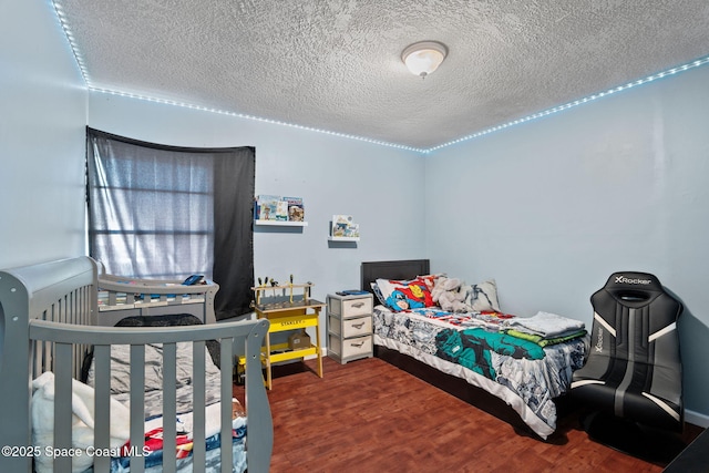bedroom with a textured ceiling and wood finished floors