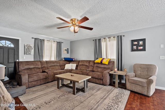living area with a ceiling fan, wood finished floors, and a textured ceiling