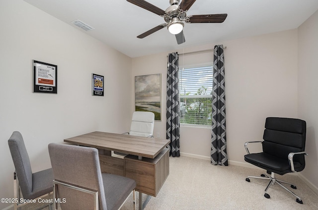 home office featuring light colored carpet, baseboards, a ceiling fan, and visible vents