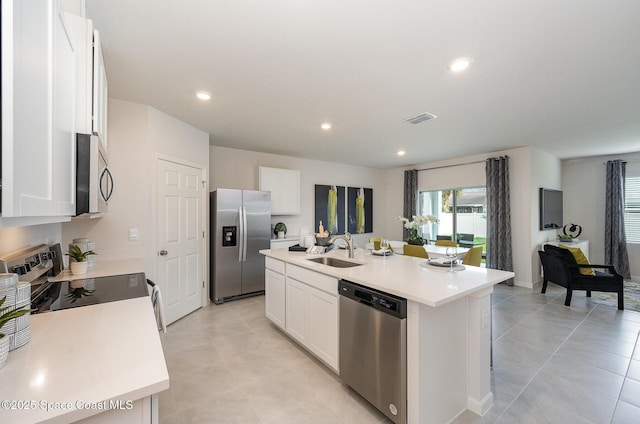 kitchen featuring visible vents, a sink, light countertops, a kitchen island with sink, and appliances with stainless steel finishes