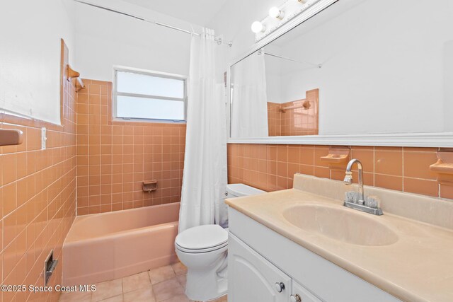 315 Cherry Ave, Merritt Island, FL 32953 - bathroom with tile walls, toilet, tile patterned floors, vanity, and shower / bath combo with shower curtain