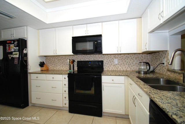 kitchen featuring black appliances, a sink, light tile patterned floors, backsplash, and white cabinets
