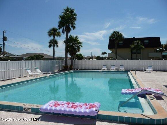 community pool featuring a fenced backyard and a patio