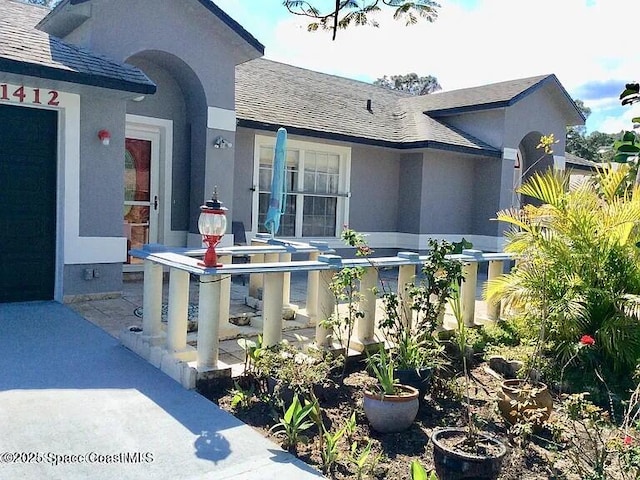 1412 Napanee St NW, Palm Bay, FL 32907 - exterior space featuring stucco siding and roof with shingles
