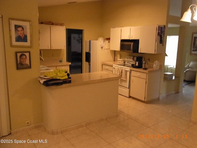1412 Napanee St NW, Palm Bay, FL 32907 - kitchen featuring light tile patterned floors, white appliances, light countertops, and white cabinetry