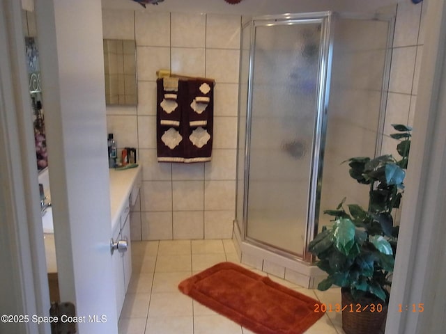 1412 Napanee St NW, Palm Bay, FL 32907 - bathroom featuring tile patterned flooring, tile walls, a shower stall, and vanity