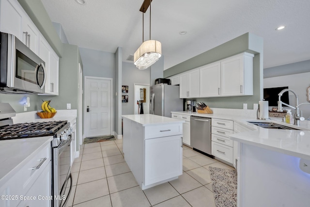 4220 Savannahs Trl, Merritt Island, FL 32953 - kitchen with stainless steel appliances, a sink, white cabinets, light countertops, and decorative light fixtures