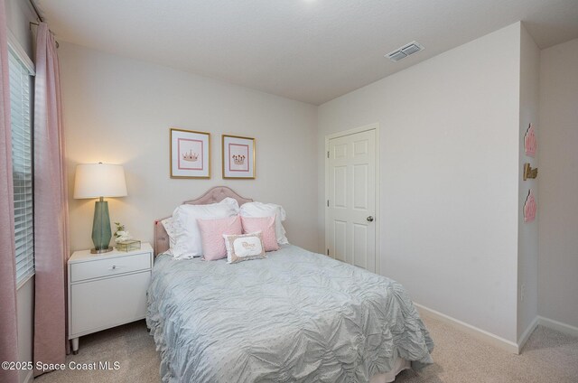 carpeted bedroom with visible vents and baseboards