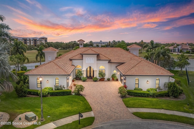 7346 Gorda Peak Ct, Melbourne, FL 32940 - mediterranean / spanish-style house with decorative driveway, an attached garage, a tile roof, and a lawn